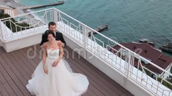 新郎新娘站在阳台上眺望大海视频的预览图