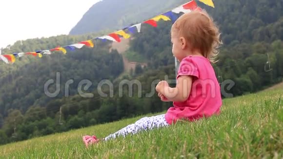 在炎热的夏日小宝宝坐在山上的绿草上全高清1920x1080视频的预览图