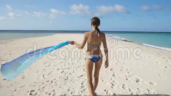 穿丝绸衣服的女孩走在海滩上视频的预览图