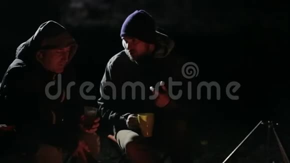 两个高加索朋友的夜射在篝火旁进行讨论视频的预览图