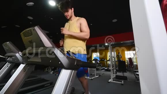 一个男人在健身房的跑步机上慢动作视频的预览图