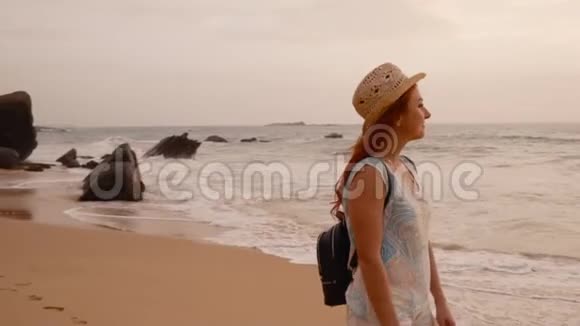 日落时分年轻女子在海边散步视频的预览图