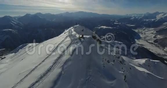 一群人正在白雪覆盖的山顶上休息无人机的视频视频的预览图