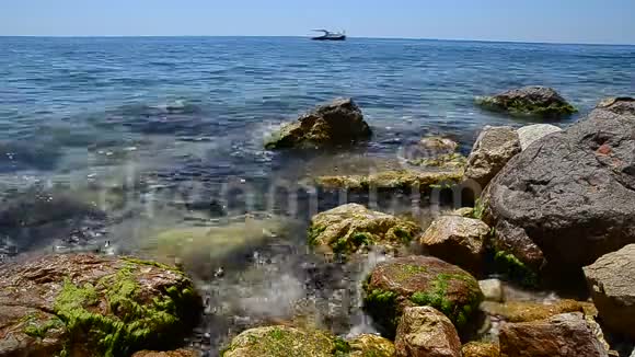 夏季海景岩石海滩的蔚蓝的海水或海洋在背景下一艘游艇航行希腊视频的预览图