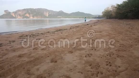 小女孩在日出时沿着海滩奔跑视频的预览图