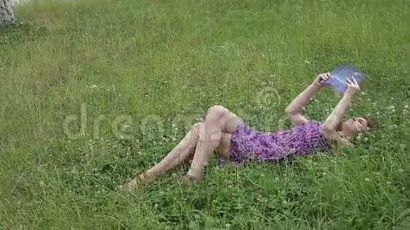 大自然中的女孩躺在草地上看书视频的预览图