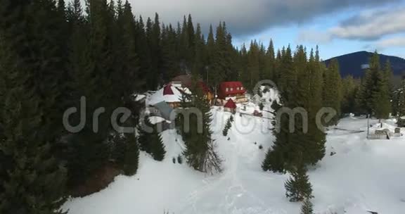 冬季山区森林中部房屋的空中勘测视频的预览图