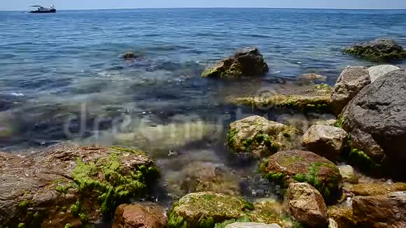 夏季海景岩石海滩的蔚蓝的海水或海洋在背景下一艘游艇航行希腊视频的预览图