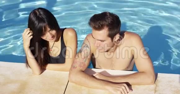 微笑的情侣站在清澈的池波中视频的预览图