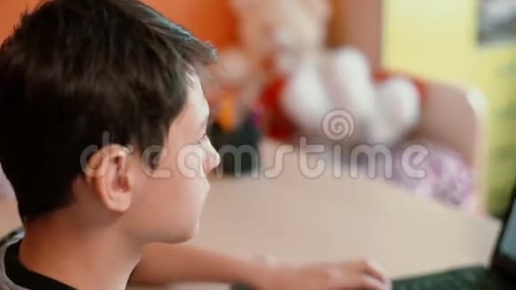 听力障碍青少年使用笔记本电脑坐在桌子旁视频的预览图