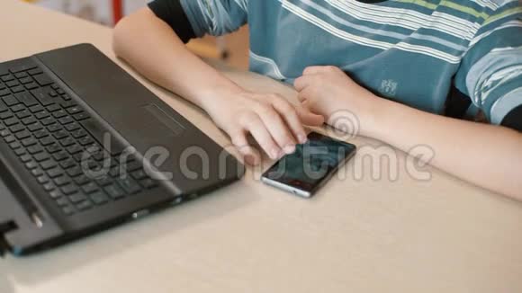 电脑桌上的男青年热情地在智能手机上打短信视频的预览图