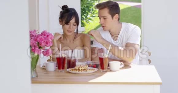 一对夫妇在户外餐桌上吃早餐视频的预览图