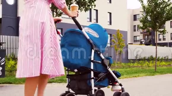 母亲带着婴儿车和咖啡在城市视频的预览图