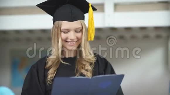 一名持有高等教育文凭并微笑的毕业生视频的预览图