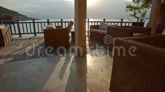 日落后的沙滩咖啡馆里小女孩坐在扶手椅上视频的预览图