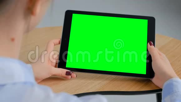 女人看着有绿色屏幕的平板电脑色度关键概念视频的预览图
