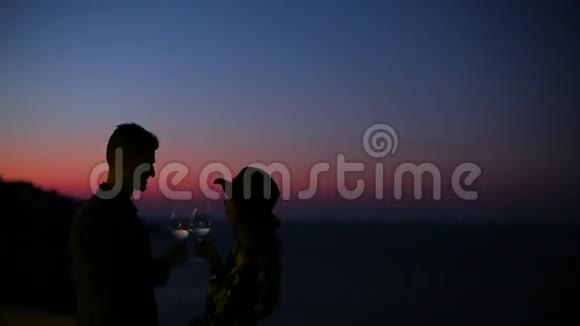 日落时分在海边喝酒的夫妇视频的预览图
