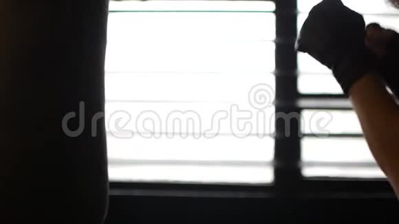 一个男人在打拳击袋运动员在一个真正的健身房训练拳击慢动作视频拍摄视频的预览图