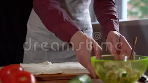 女性用手做皮塔和肉屑并在厨房添加蔬菜视频的预览图