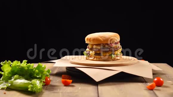 新鲜美味的汉堡在黑色背景上旋转视频的预览图