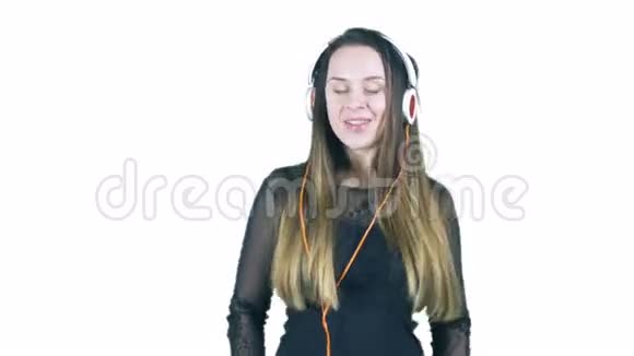 年轻的女人一边在耳机里听音乐一边做滑稽的脸视频的预览图
