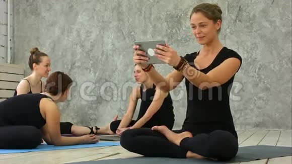 健身女孩使用电脑平板电脑在线会议与团体在瑜伽课视频的预览图