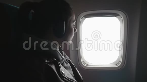 年轻女子乘飞机旅行坐在窗边欣赏风景视频的预览图