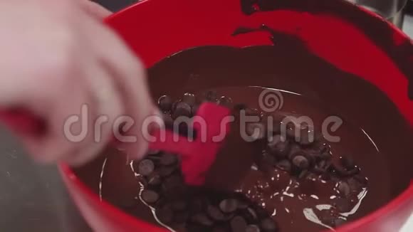 糖果女手用刮刀搅动融化的巧克力视频的预览图
