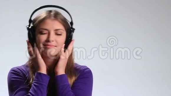 性感女人用耳机听音乐视频的预览图