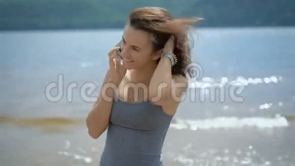 一个年轻漂亮的女人在海滩上用智能手机和男朋友说话视频的预览图