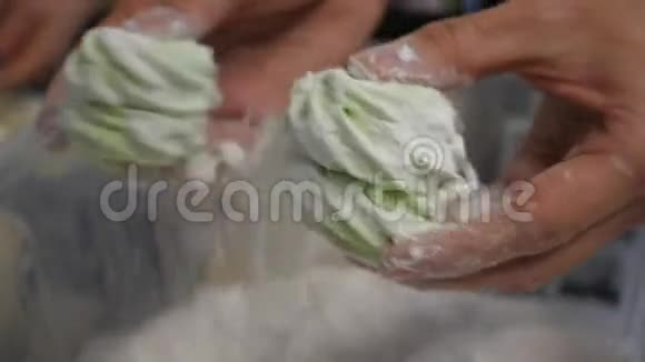 女人双手撒着糖霜用筛子做糖果洒在棉花糖上视频的预览图