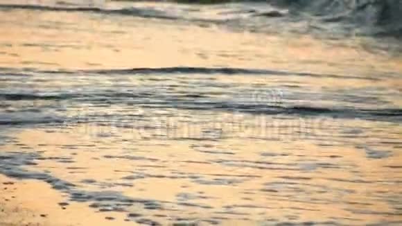 海浪冲刷着岸边的沙傍晚昏暗的灯光黎明慢动作视频的预览图