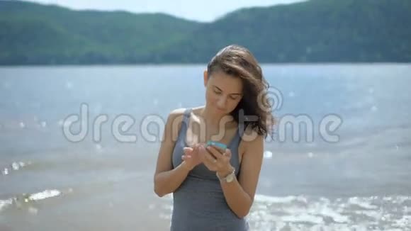一位年轻漂亮的女士站在海滩上订了旅馆视频的预览图