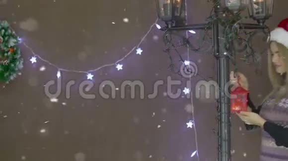 美丽的金发圣诞女孩在圣诞装饰的背景上挂着红灯笼视频的预览图