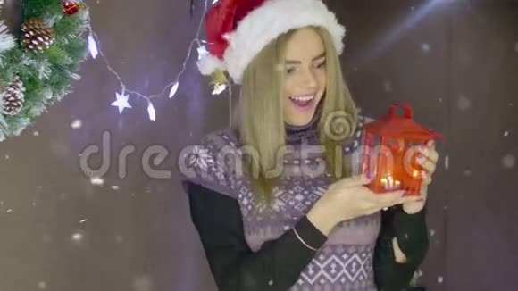美丽的金发圣诞女孩在圣诞装饰的背景上挂着红灯笼视频的预览图