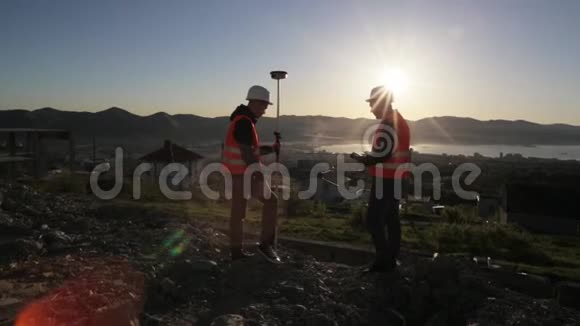 两名头盔测量员在山顶进行测地测量视频的预览图