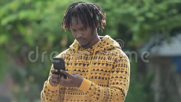 年轻英俊的非洲男人在户外街头打电话视频的预览图