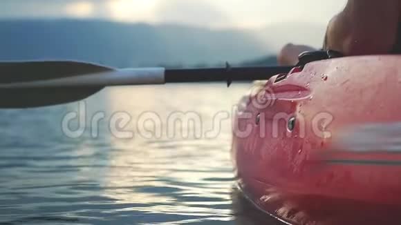 靠近皮划艇坐在皮划艇上看起来令人惊叹的日落慢动作1920x1080视频的预览图