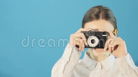 在摄影棚中使用蓝底摄影机拍摄了可爱的不伦内特戴眼镜和衬衫的特写肖像视频的预览图