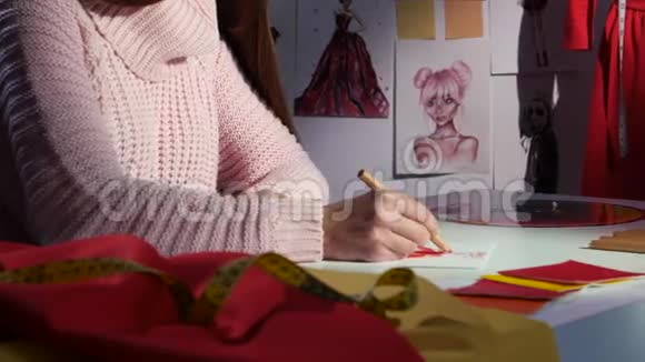 手设计师画一幅连衣裙的草图在布桌上用于裁剪关门视频的预览图