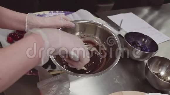 甜点煮手搅拌融化的巧克力在金属搅拌碗视频的预览图