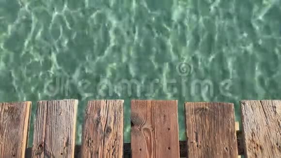 夏季背景旧木板码头和海水与阳光反射视频的预览图