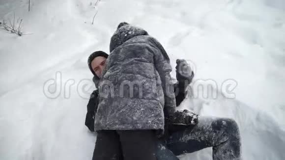 女孩和男孩在雪地里闲逛和躺着视频的预览图