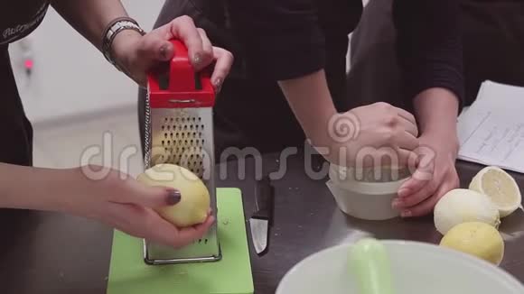 女厨师在围裙使用烤架和榨汁机与柠檬在厨房餐桌视频的预览图