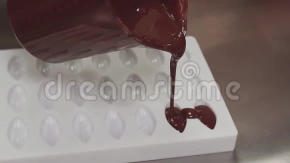 糖果把融化的巧克力倒入白色塑料模具视频的预览图