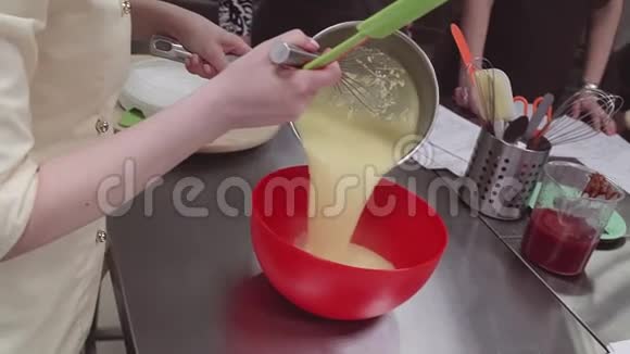 女糖果手把蛋羹倒入厨房的搅拌碗里视频的预览图