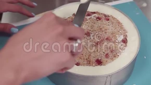 女性糖果师用手在烤制的蛋糕上抹上奶油视频的预览图
