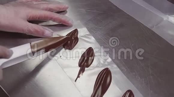 女糕点师用刀刮碎巧克力叶形装饰视频的预览图