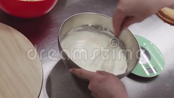 女性糕点厨师用搅拌器在金属搅拌碗中制作鲜奶油视频的预览图