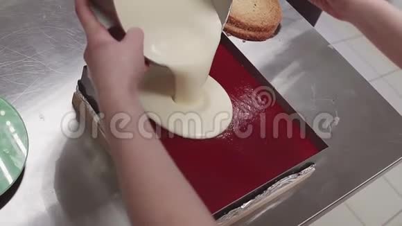 女性手在厨房的烤盘里将蛋奶奶饼倒入分层蛋糕上视频的预览图
